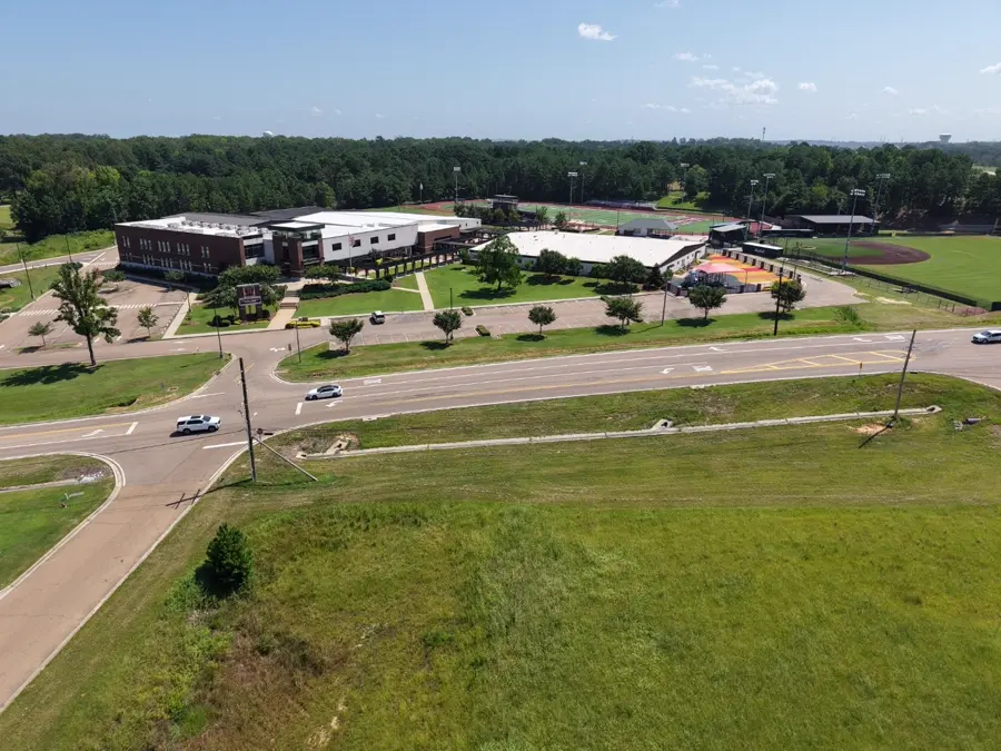 Aerial view of a school campus with athletic fields and a large rooftop