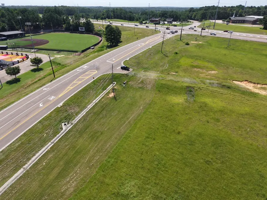 Aerial view of a roadway intersection near a school and athletic fields