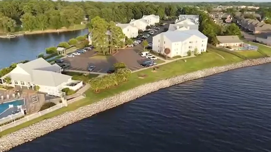 Aerial view of a waterfront residential community with pool and clubhouse